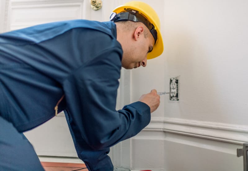 Technicians inspecting a residential electrical panel for safety and compliance.